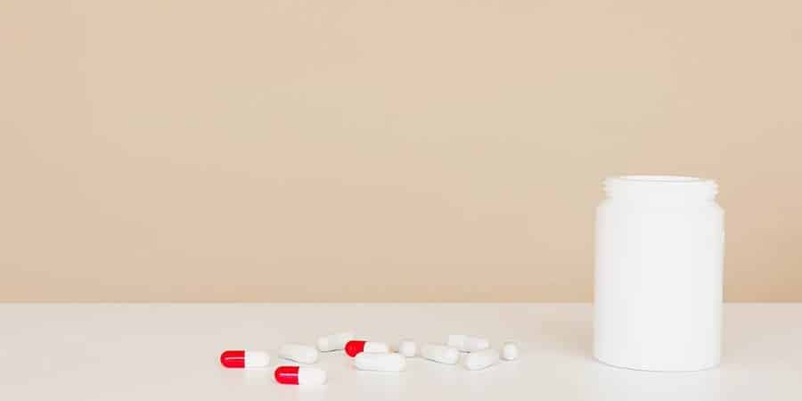 pills on a table next to pill bottle