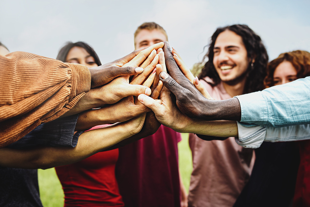 Group of happy people all touching hands